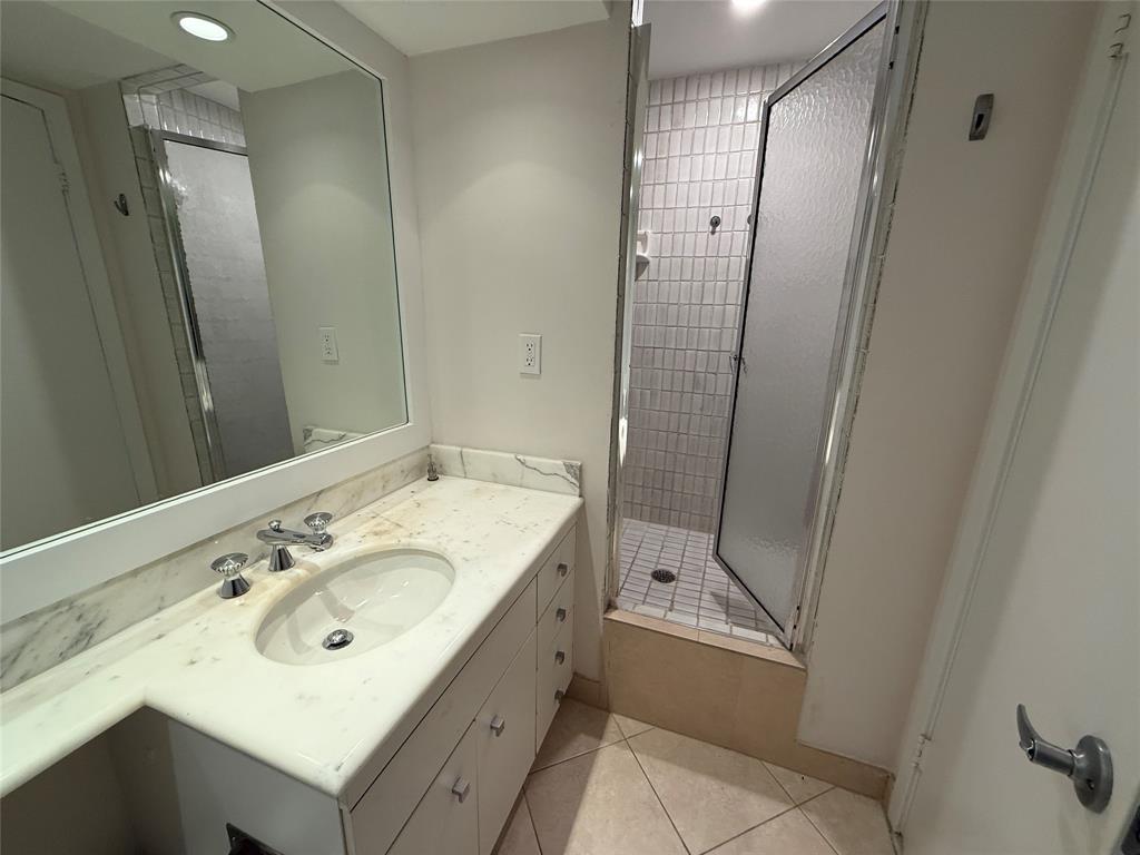 19707 Turnberry Way, Unit 7C Aventura, FL 33180 - Photo 20 of 40 a bathroom with a double vanity sink mirror and shower