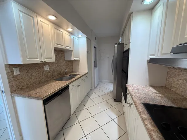 a kitchen with stainless steel appliances granite countertop a refrigerator and a stove