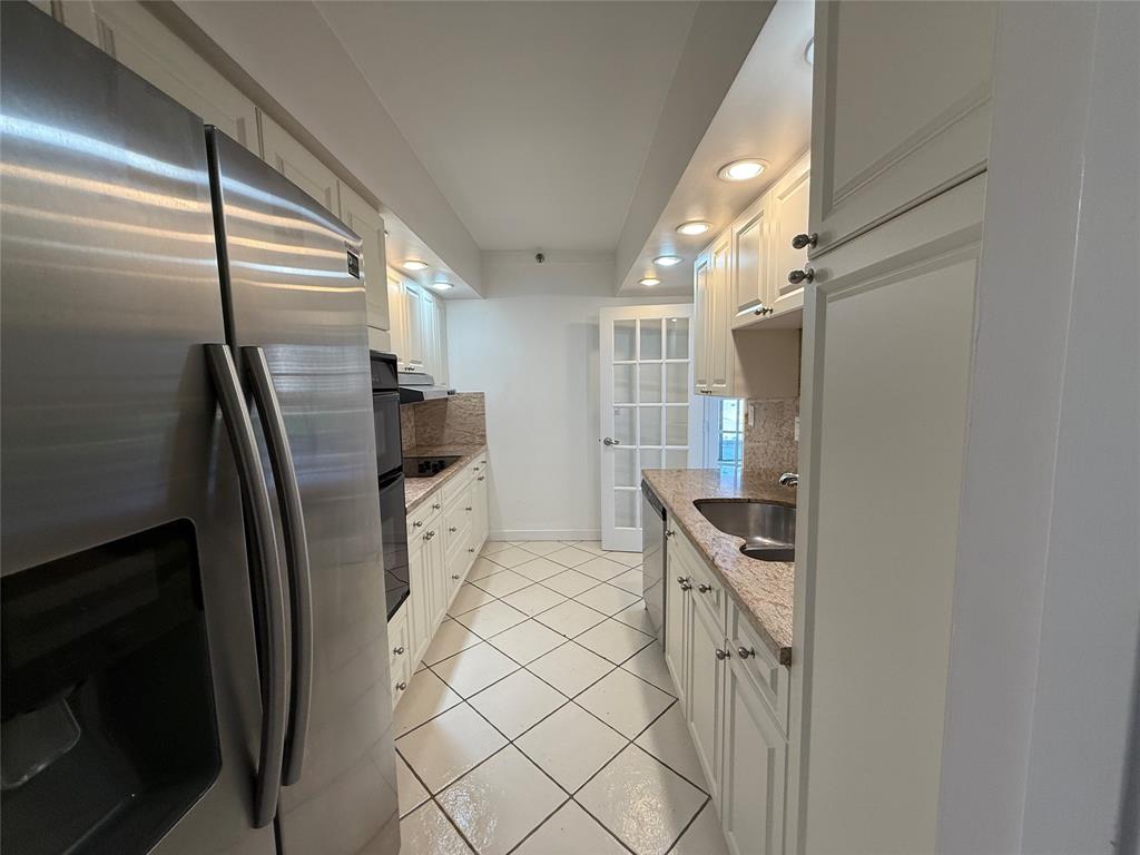 19707 Turnberry Way, Unit 7C Aventura, FL 33180 - Photo 8 of 40 a kitchen with stainless steel appliances granite countertop a refrigerator and a stove