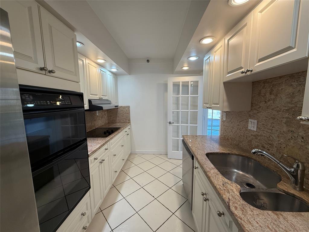 19707 Turnberry Way, Unit 7C Aventura, FL 33180 - Photo 9 of 40 a kitchen with granite countertop a sink dishwasher stove and cabinets