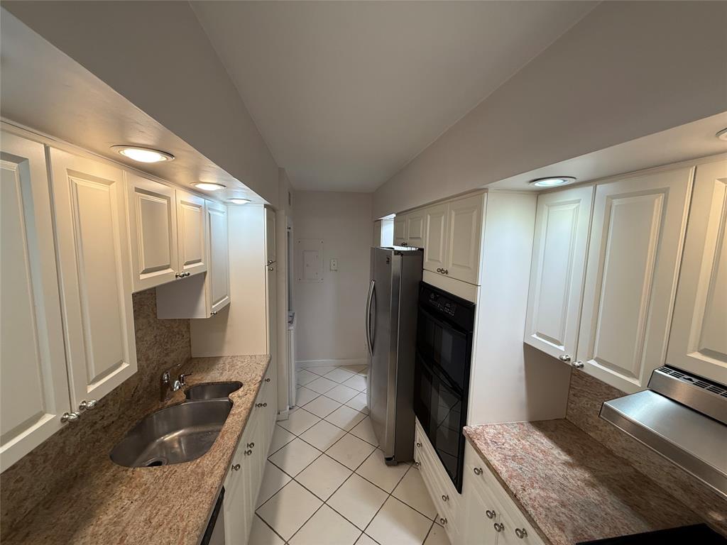 19707 Turnberry Way, Unit 7C Aventura, FL 33180 - Photo 10 of 40 a bathroom with a granite countertop sink and a large mirror