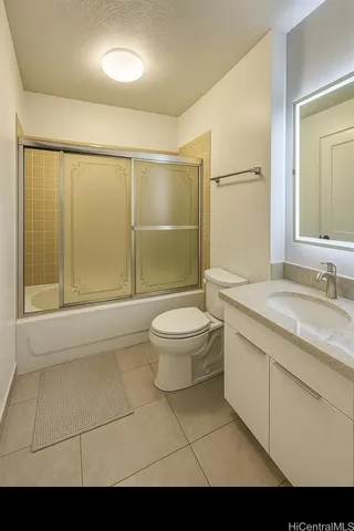 a bathroom with a granite countertop sink a toilet a mirror and shower