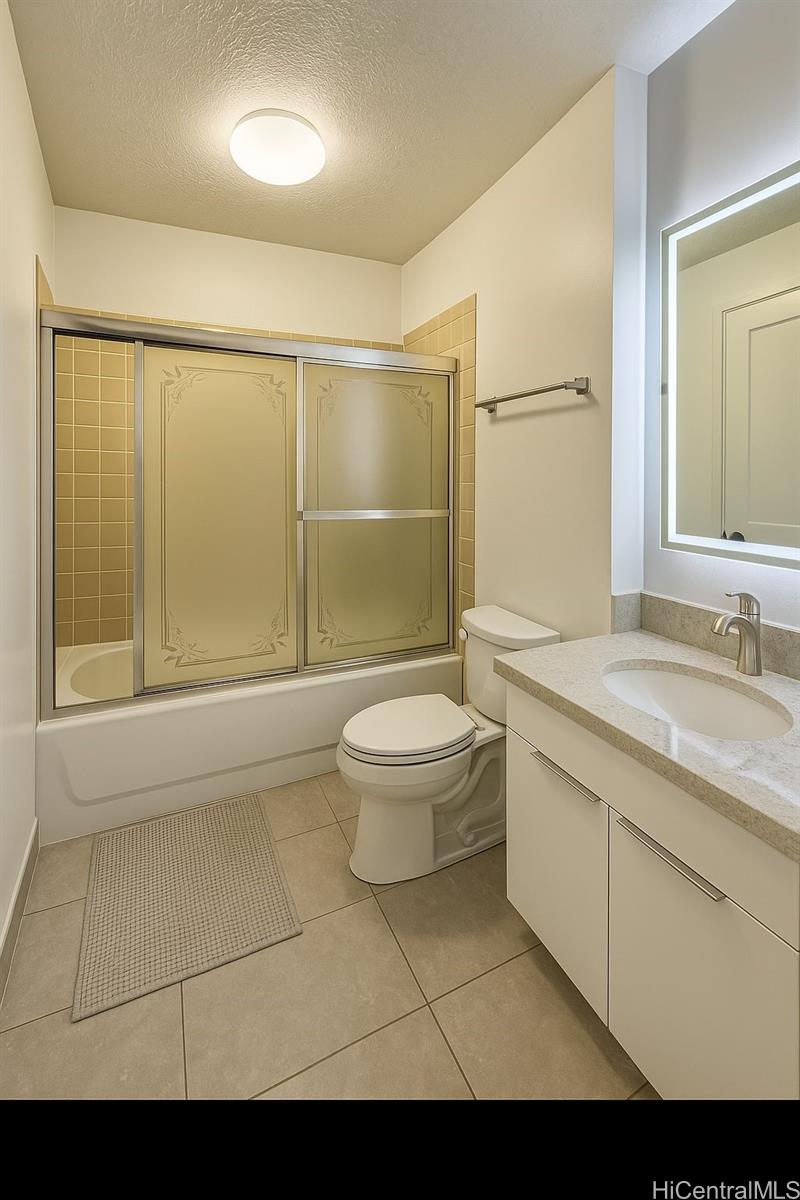 775 Kinalau Place, Unit 1408 Honolulu, HI 96813 - Photo 7 of 12 a bathroom with a granite countertop sink a toilet a mirror and shower