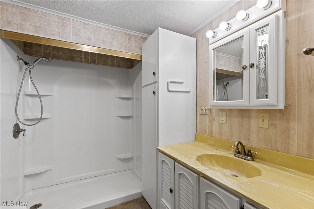 54885 Mt Victory Road Powhatan Point, OH 43942 - Photo 13 of 32 Bathroom with vanity, a shower stall, ornamental molding, and a textured ceiling