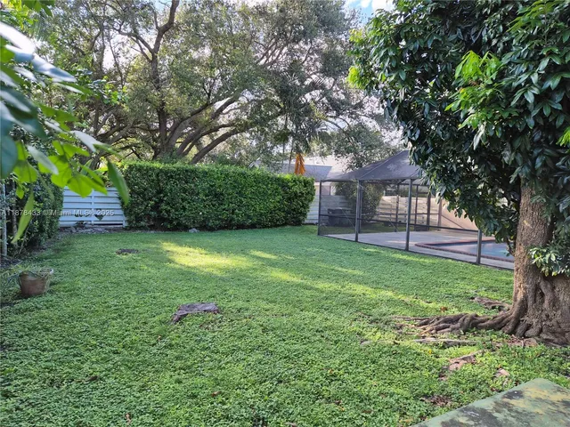 a view of backyard with huge green area and large trees