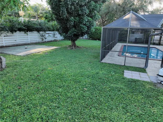 a view of a yard with plants and trees