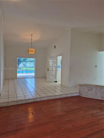 a view of a room with wooden floor and a window