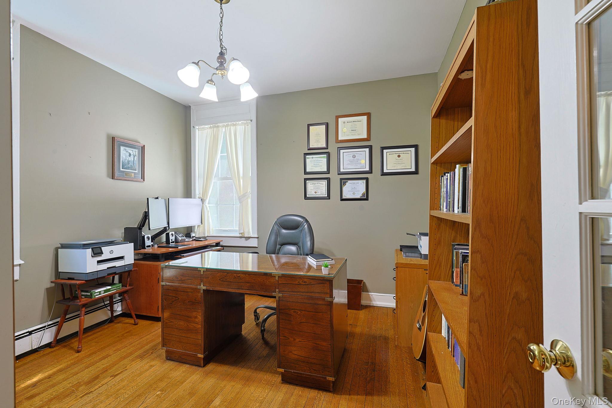 9 Library Road Tuxedo Park, NY 10987 - Photo 7 of 37 Office/Den/ possible as additional bedroom featuring hardwood flooring, a window with natural light, and a built-in wooden bookcase