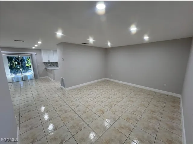 wooden floor in an empty room with a kitchen