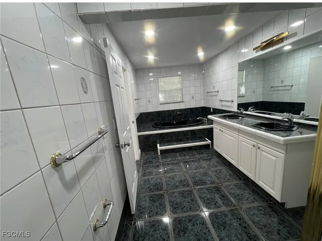 a kitchen with granite countertop a stove and white cabinets