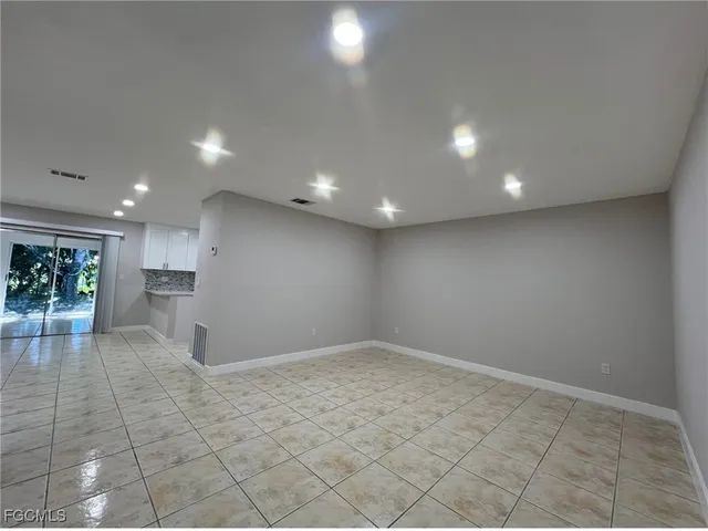 an empty room with kitchen appliances and windows
