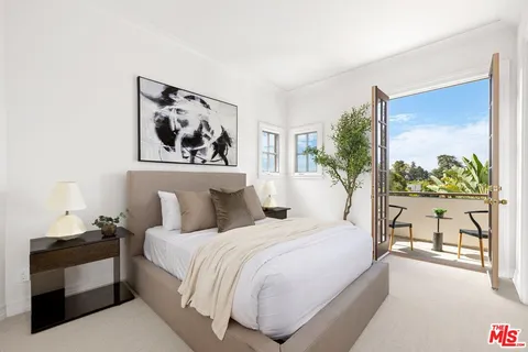 a bedroom with a large bed and a painting on the wall