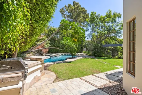 a view of a swimming pool with lawn chairs under an umbrella