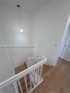 a view of staircase with railing and white walls