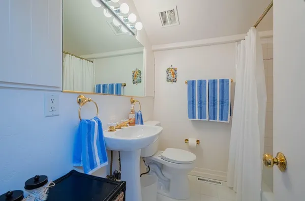 a bathroom with a sink toilet and mirror