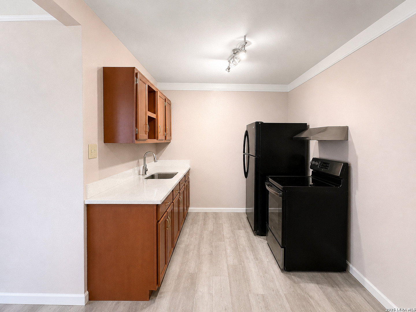 118 Stonegate South, Unit 2 Boerne, TX 78006 - Photo 3 of 7 a kitchen with a sink and refrigerator