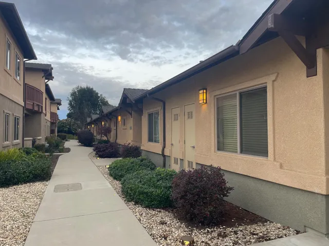 a front view of a house with a yard and trees