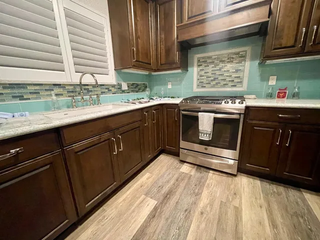 a kitchen with stainless steel appliances granite countertop a sink stove and cabinets