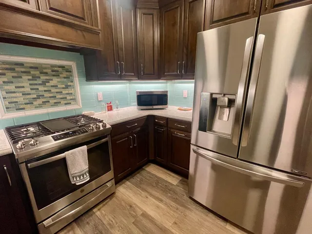 a kitchen with wooden cabinets and stainless steel appliances