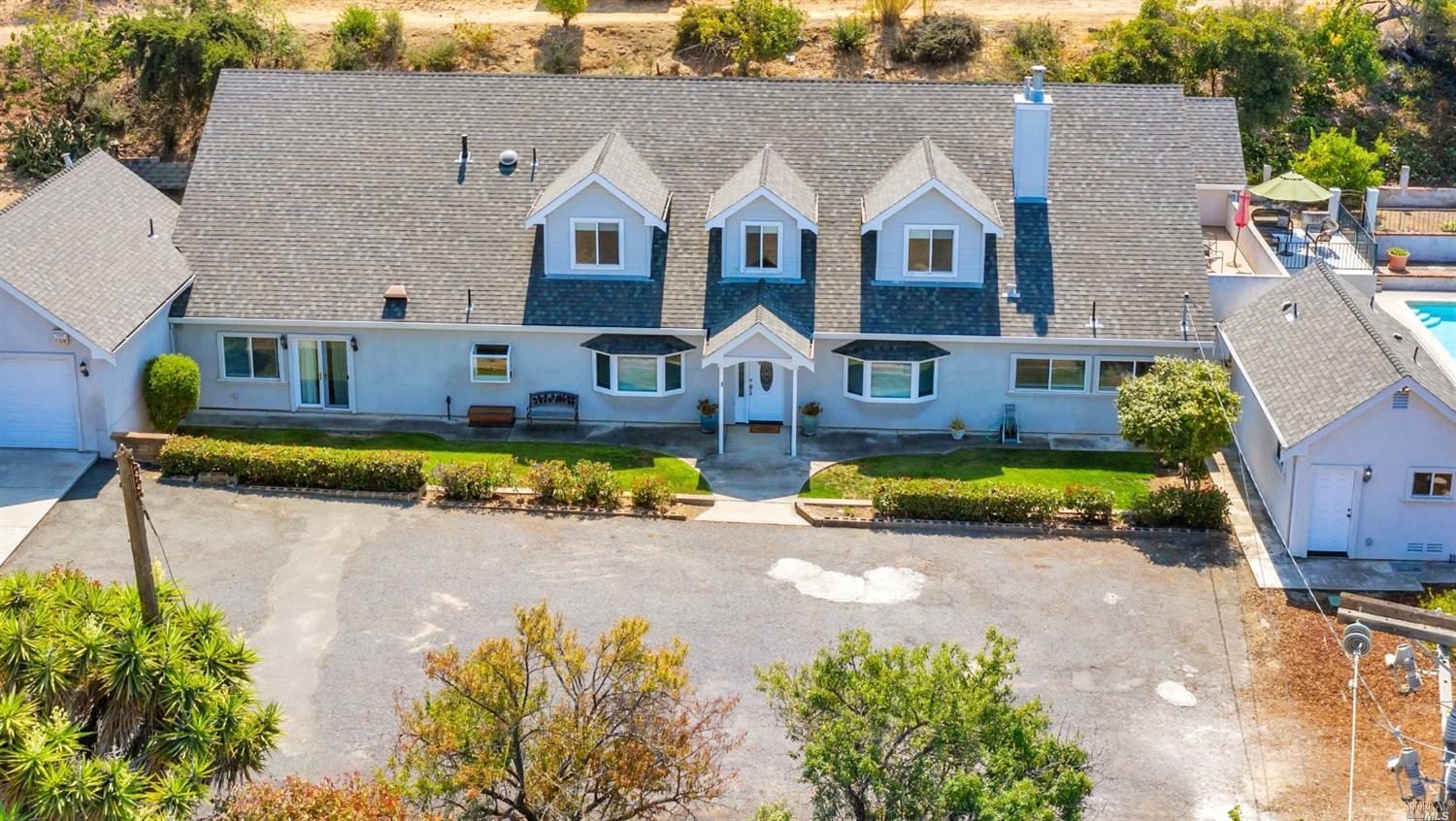 an aerial view of a house with swimming pool and a yard