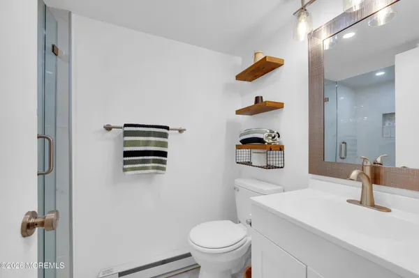 a bathroom with a sink a toilet and shower