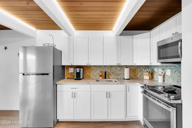 a kitchen with a sink a refrigerator and cabinets