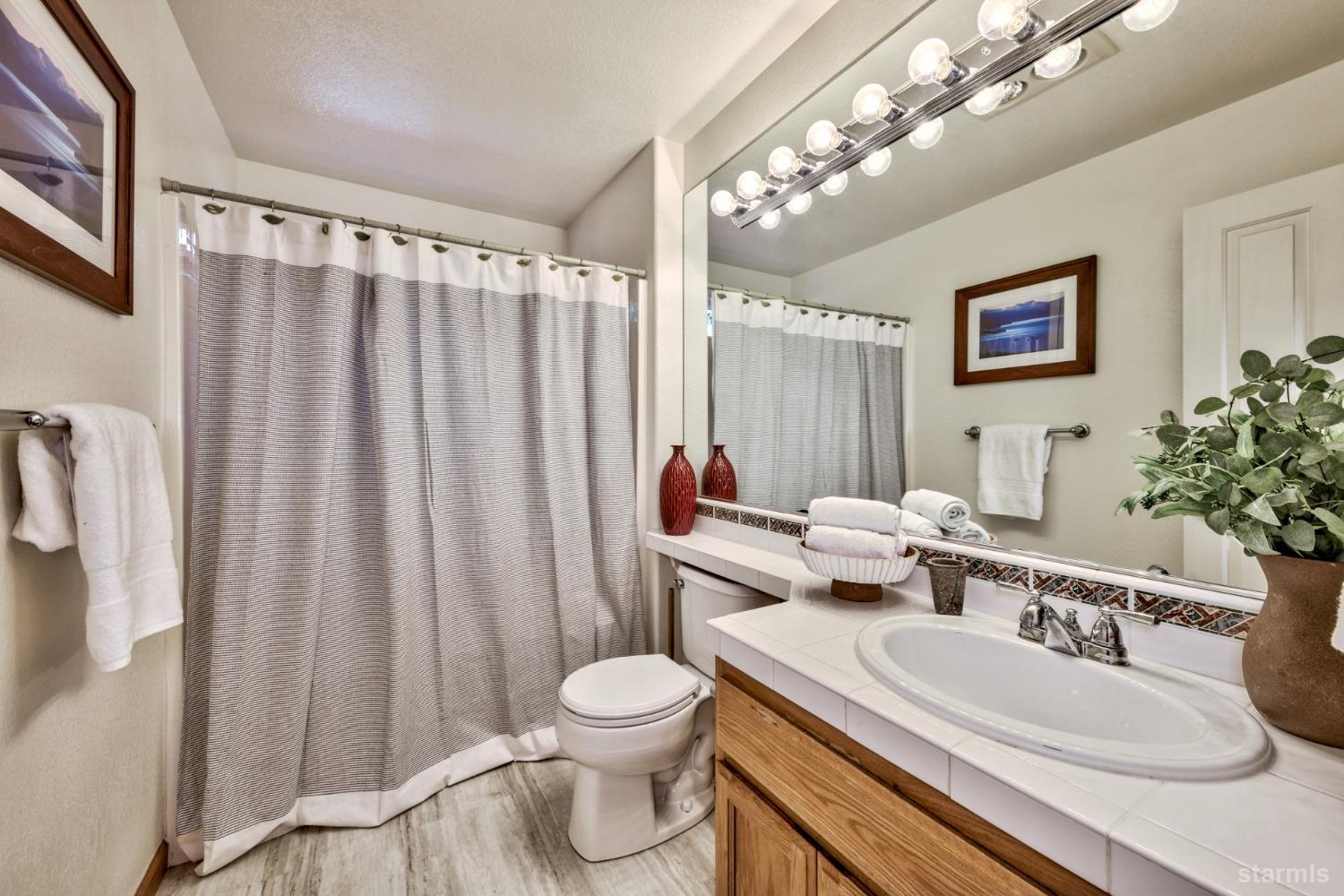 1569 Aztec Way South Lake Tahoe, CA 96150 - Photo 19 of 22 a bathroom with a toilet a sink and a mirror