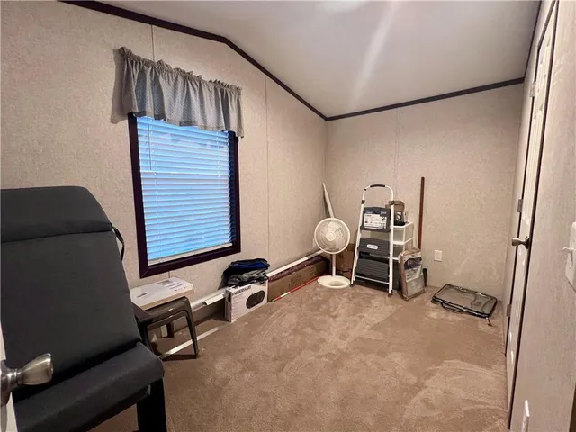 a view of a workspace with furniture and a window