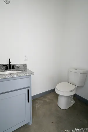 a bathroom with a granite countertop toilet and a sink