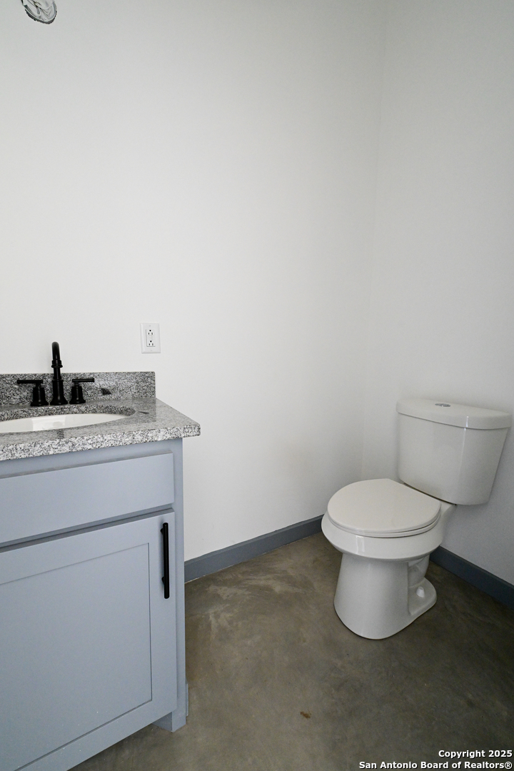 1003 West Galveston Street Marfa, TX 79843 - Photo 13 of 23 a bathroom with a granite countertop toilet and a sink