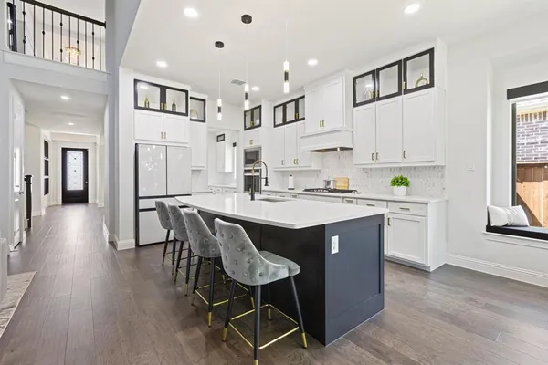 a kitchen with stainless steel appliances kitchen island a table chairs refrigerator sink and cabinets
