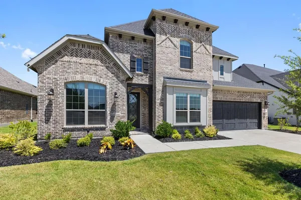 a front view of a house with a yard and potted plants