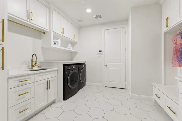 a utility room with cabinets washer and dryer