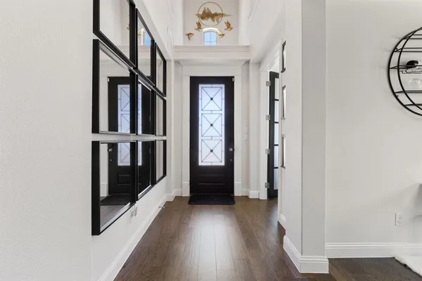 a view of an entryway with wooden floor door and windows