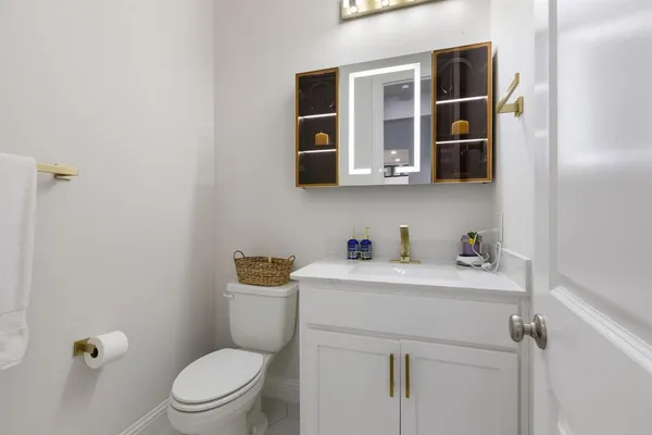 a bathroom with a toilet sink a vanity and mirror