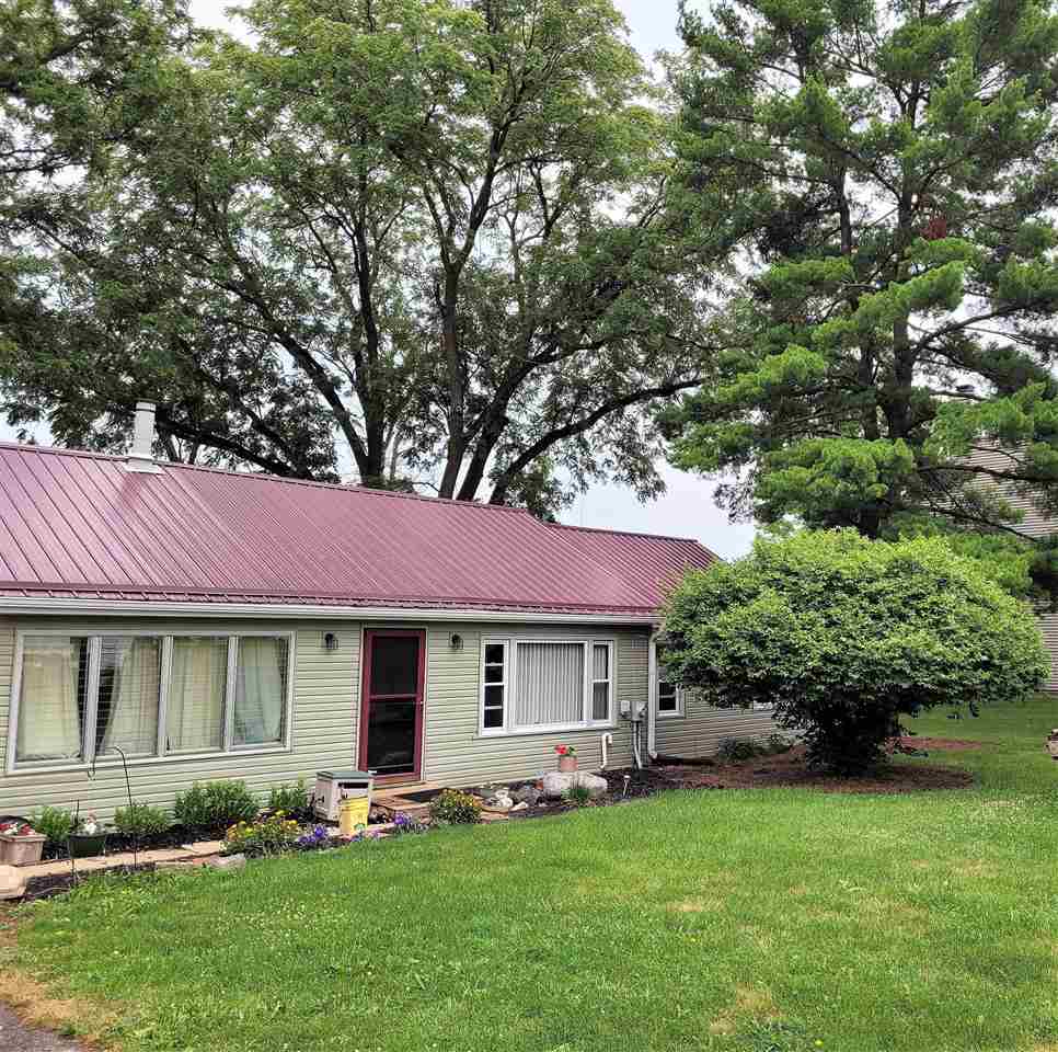 7504 North River Road Byron, IL 61010 - Photo 2 of 46 a front view of a house with a garden