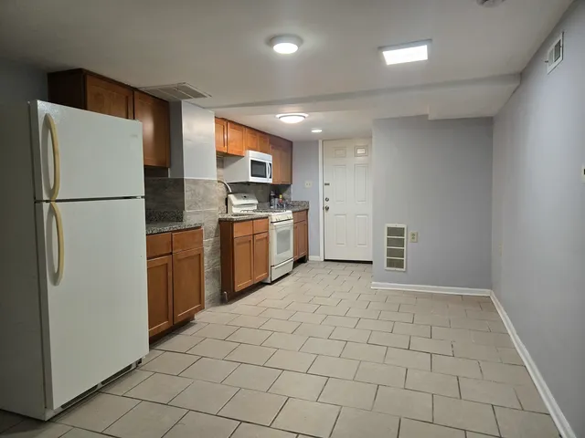 a kitchen with granite countertop a sink stainless steel appliances and cabinets