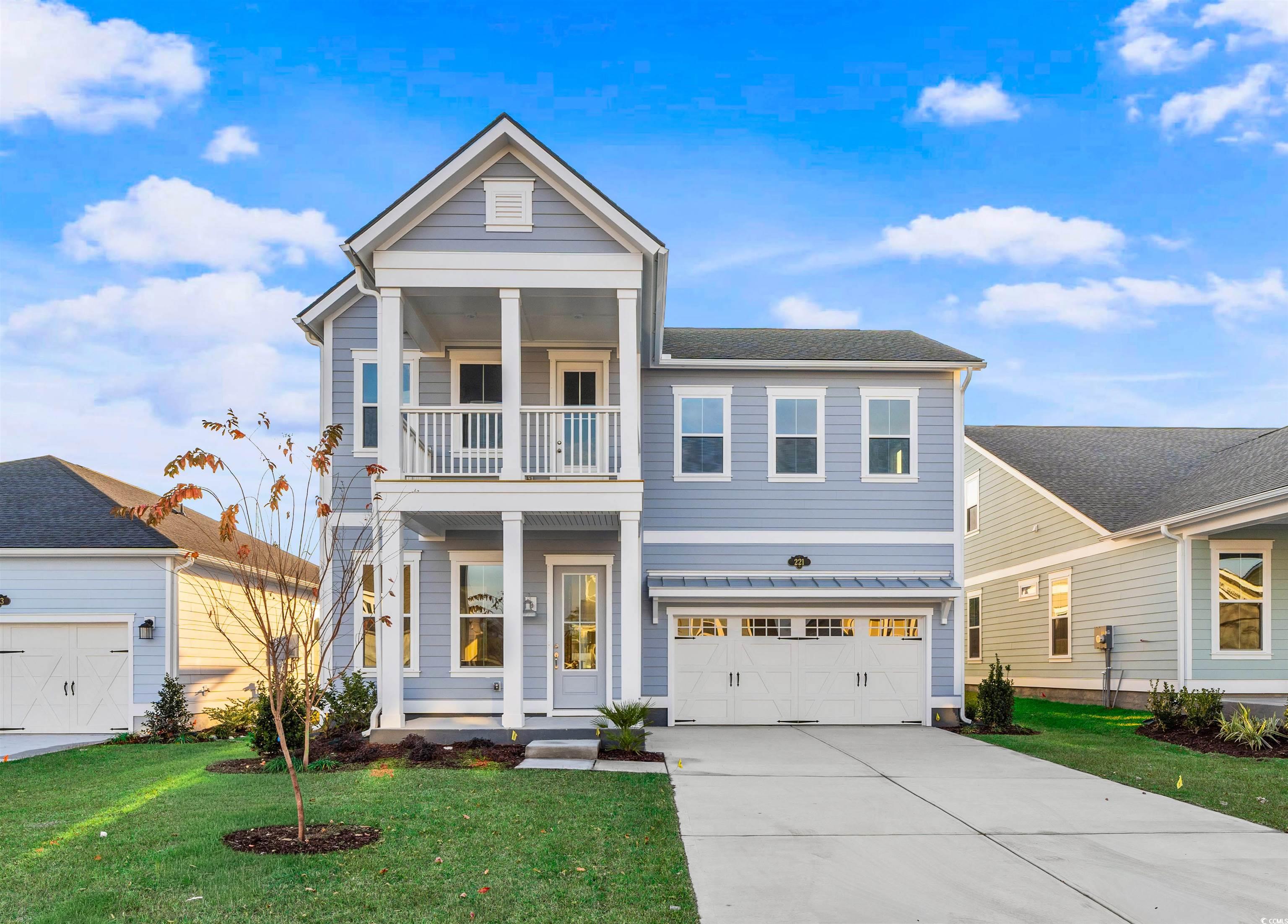 View of front of house featuring a porch, a front lawn, driveway, and a garage