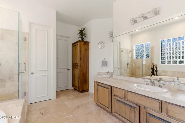 a bathroom with a granite countertop sink a mirror and a shower
