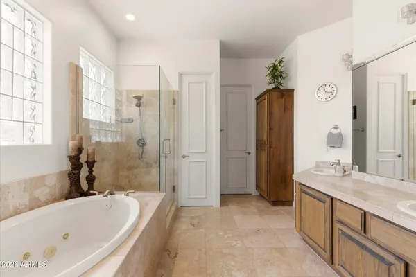 a bathroom with a tub a sink and a large mirror