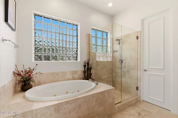 a bathroom with a tub shower and window