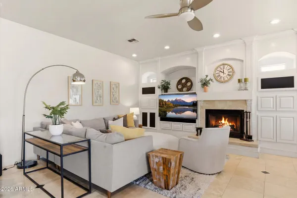 a living room with furniture a fireplace and a dining table with wooden floor