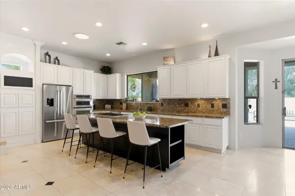a kitchen with a dining table chairs refrigerator and cabinets