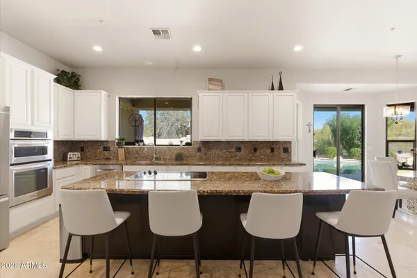 a kitchen with a dining table chairs and sink