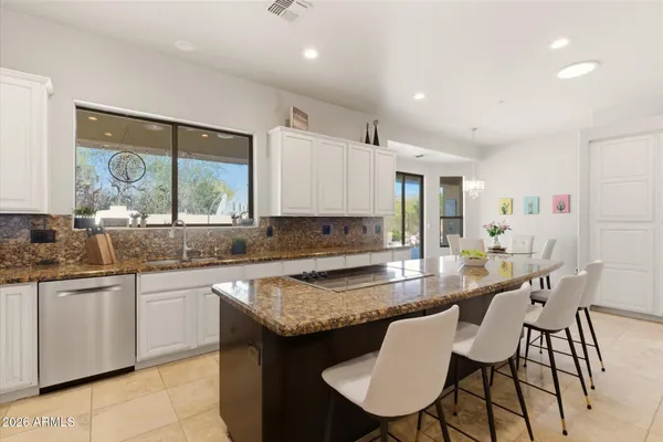 a kitchen with granite countertop kitchen island a table and chairs in it