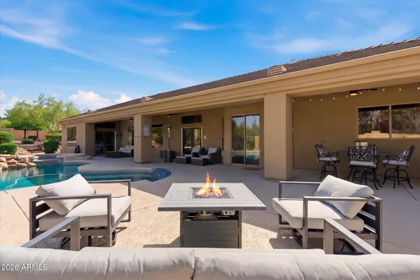 a view of a patio with couches table and chairs under an umbrella with wooden floor
