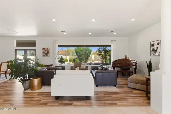 a living room with furniture a large window and a dining table