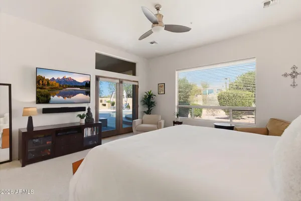 a bedroom with a bed and a flat tv screen on dresser