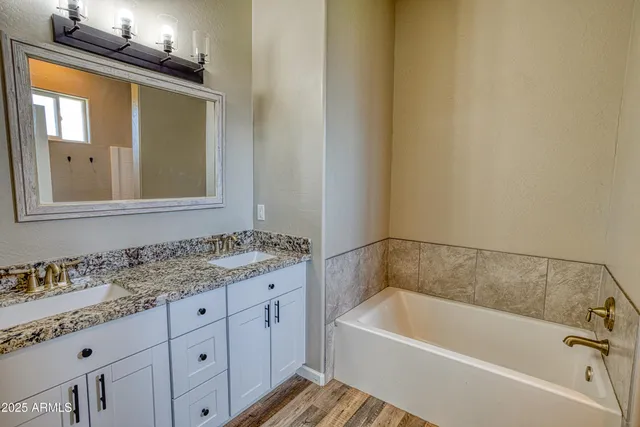 a bathroom with a granite countertop sink mirror and bathtub