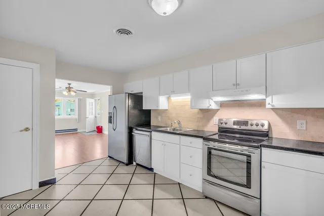 a kitchen with a stove a sink and a refrigerator